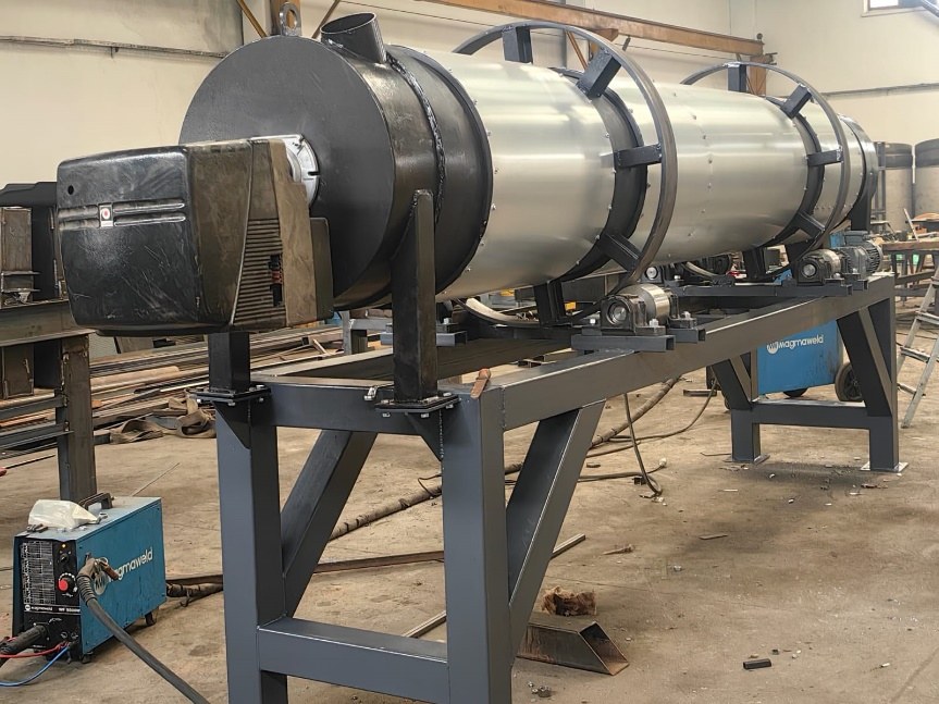 Rotary dryer or roasting drum on a charcoal steel frame during workshop assembly